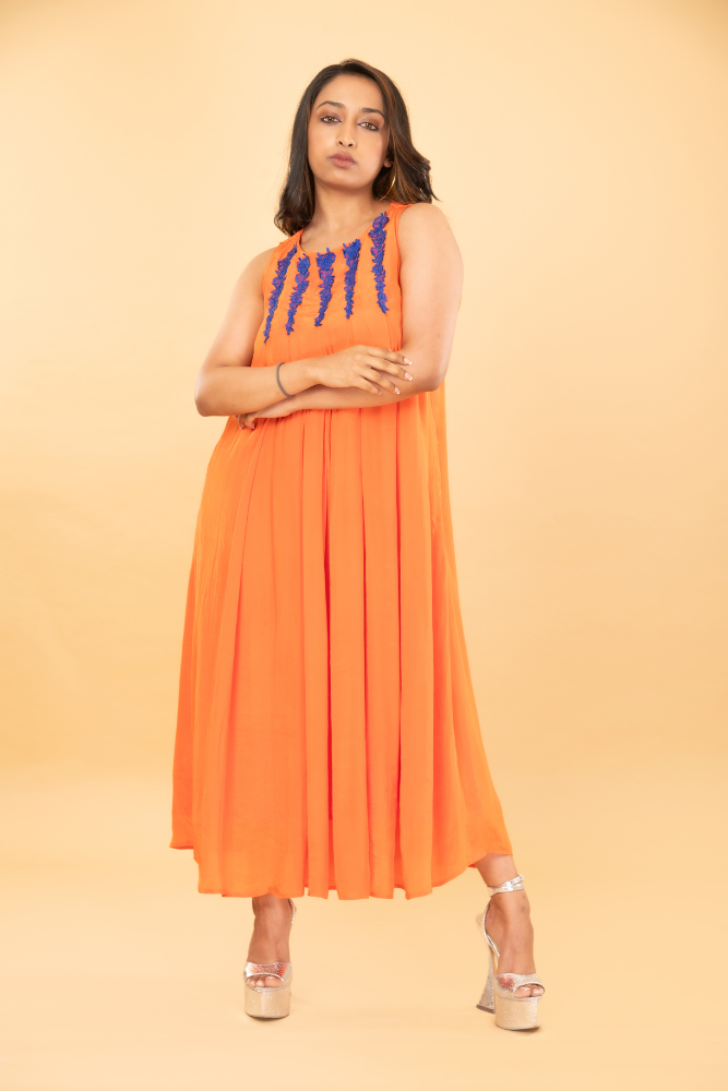 Orange box pleated tunic with blue embroidered neckline